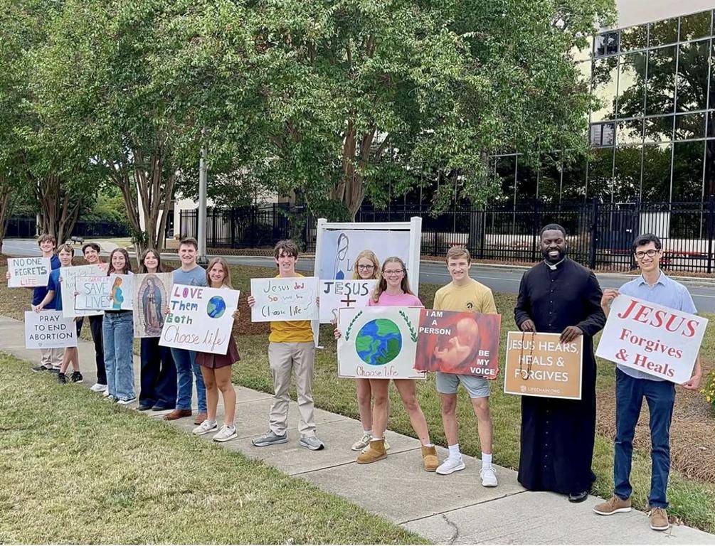 Charlotte Catholic High School's Voices for Life Club prays in front of the school on Respect Life Sunday.